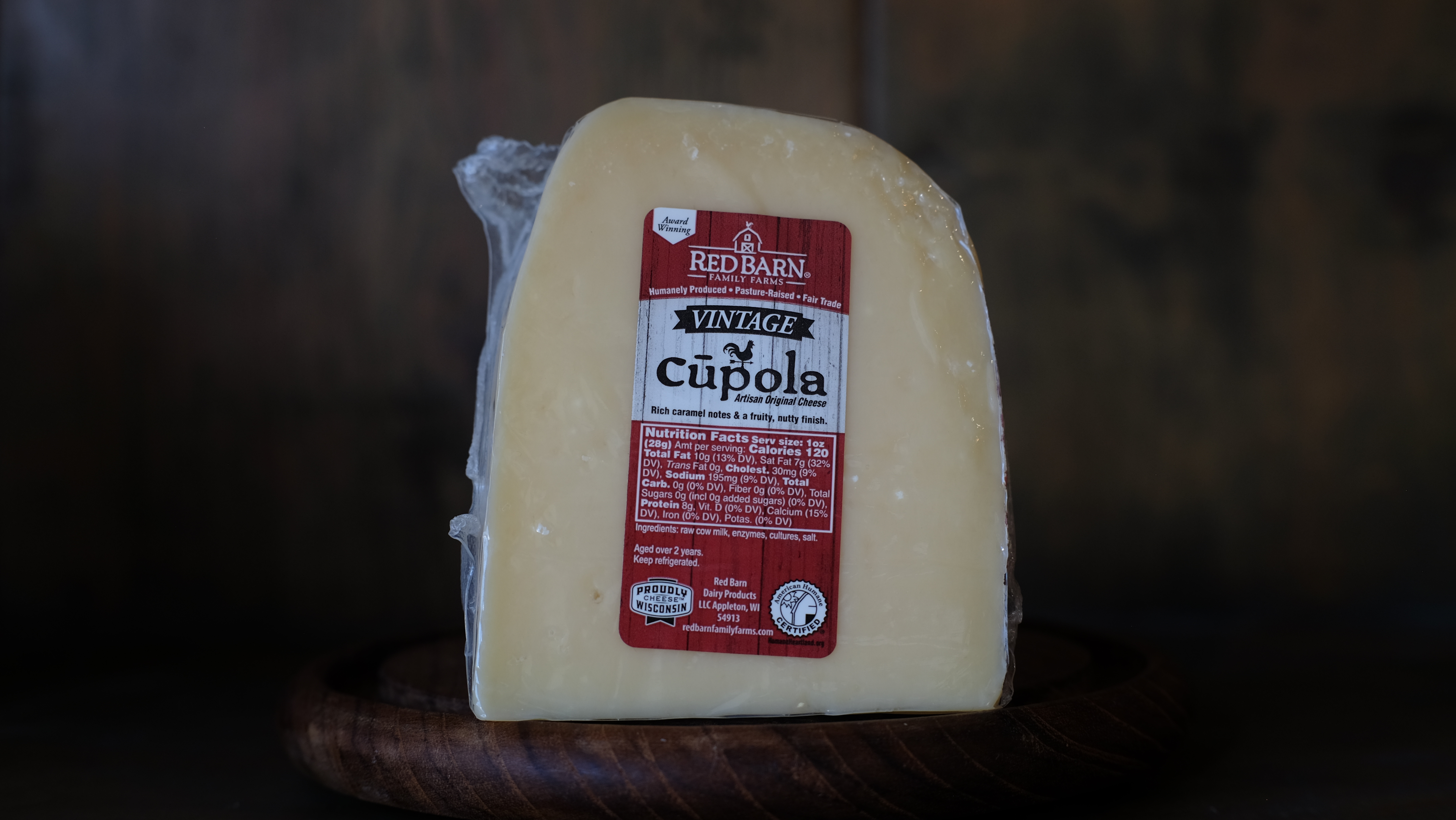 Wheel of Cupola aged Gouda cheese on a wooden board