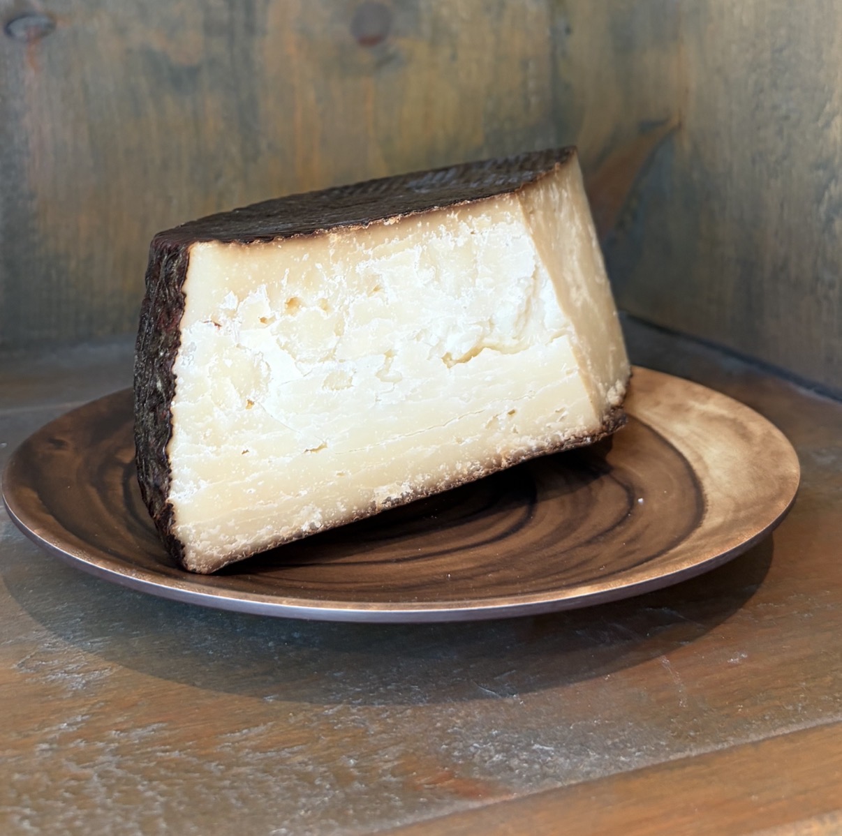 Wedge of Wischego hard sheep's milk Wisconsin cheese on a board